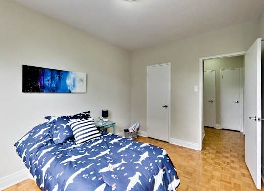 a bedroom with a bed and a blue and white comforter