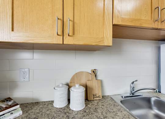 A kitchen counter with a cutting board and two containers on it.