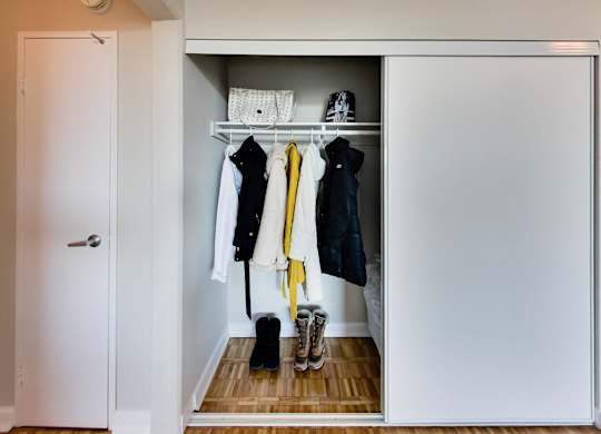 a small closet with clothes and shoes in it