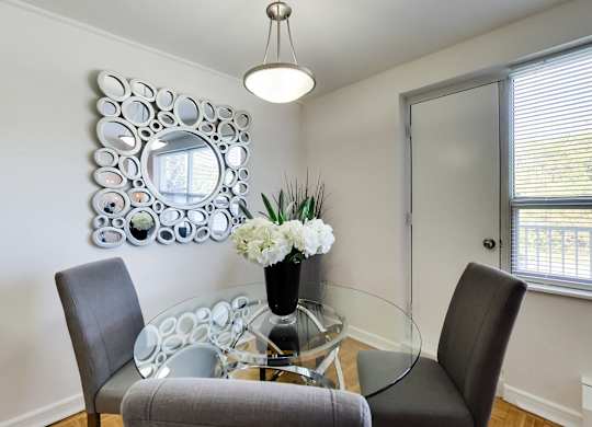 a dining room with a glass table and chairs