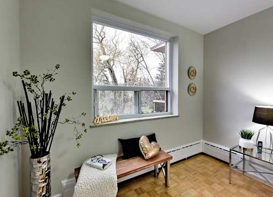 a living room with a large window and a wooden bench
