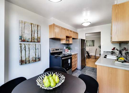 A kitchen with a table and chairs and a bowl of fruit on it.
