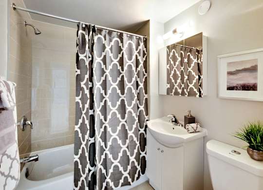 a bathroom with a shower and a sink and a toilet