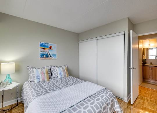 a bedroom with a bed and a mirrored wall