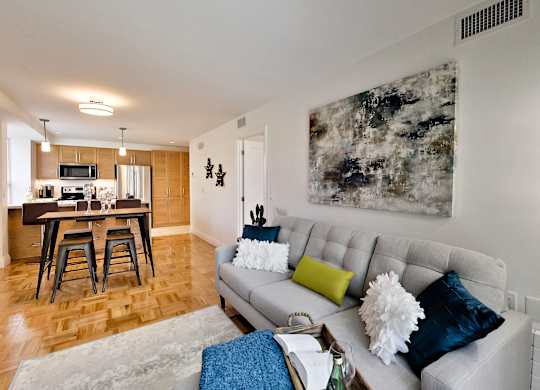 a living room with a couch and a kitchen with a bar