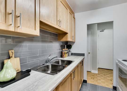a kitchen with a sink and a stove and a door to a hallway