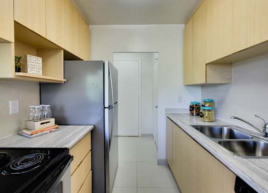 a kitchen with wooden cabinets and a stainless steel refrigerator