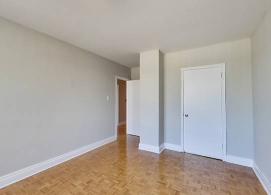 an empty living room with wood flooring and white walls