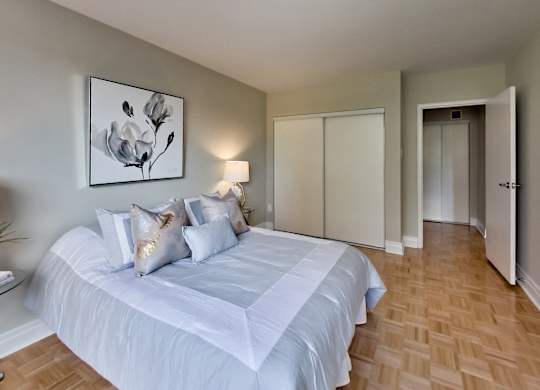 a bedroom with a white bed and a painting on the wall