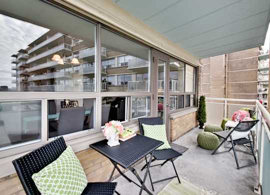 A balcony with a table and chairs is shown.