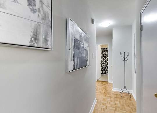 a hallway with pictures on the wall and a door to a closet