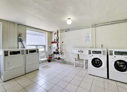 a laundry room with washing machines and a sink