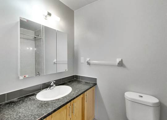 an empty bathroom with a sink toilet and mirror