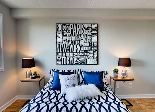 a bedroom with a bed with blue and white pillows and a sign above it