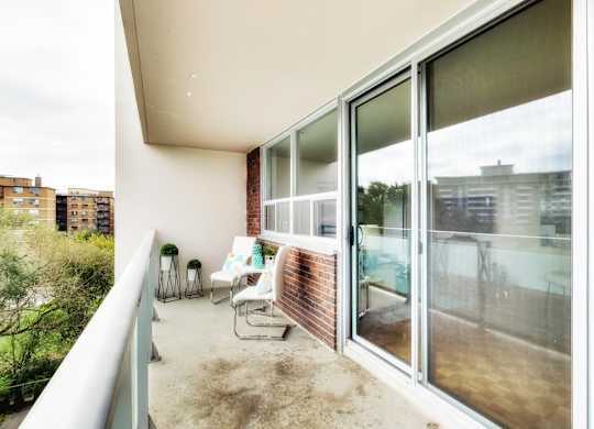 A balcony with a person sitting on a chair.