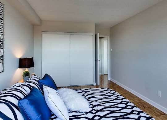 a bedroom with a bed with blue and white pillows