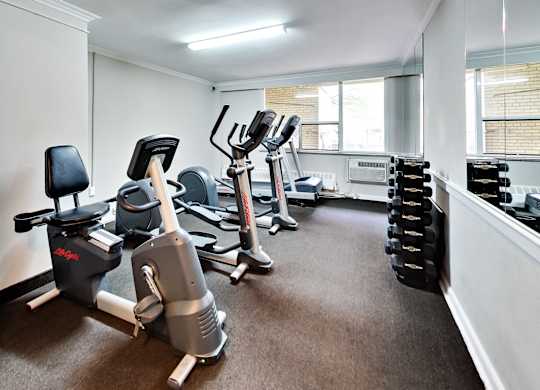 a gym with cardio machines and weights on the floor
