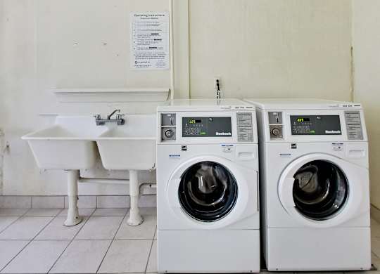 two washing machines and a sink in a laundry room