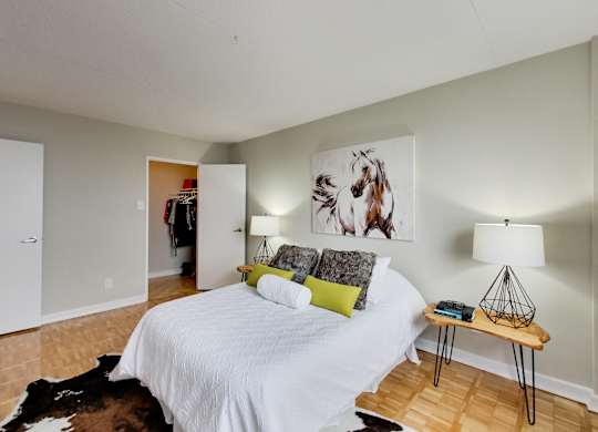 a bedroom with a white bed and a painting on the wall