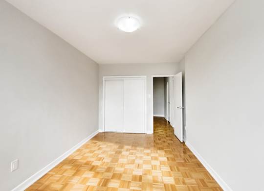 an empty living room with a wooden floor and white walls