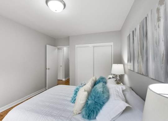 a bedroom with a large white bed with blue pillows