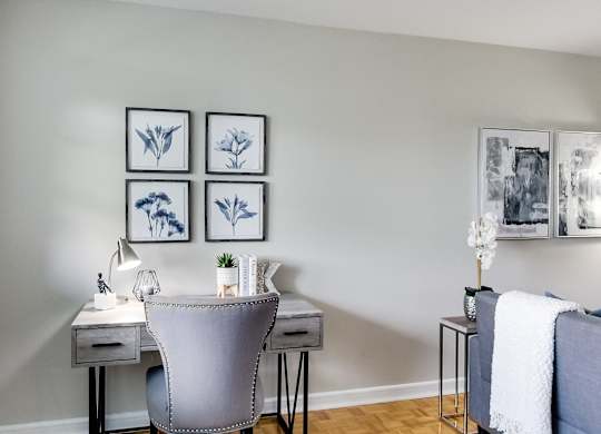 a home office with a desk and chair and pictures on the wall