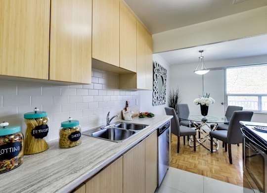 an open kitchen and dining room with a table and chairs and a sink
