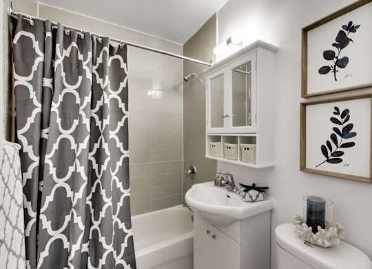 a white bathroom with a black and white shower curtain