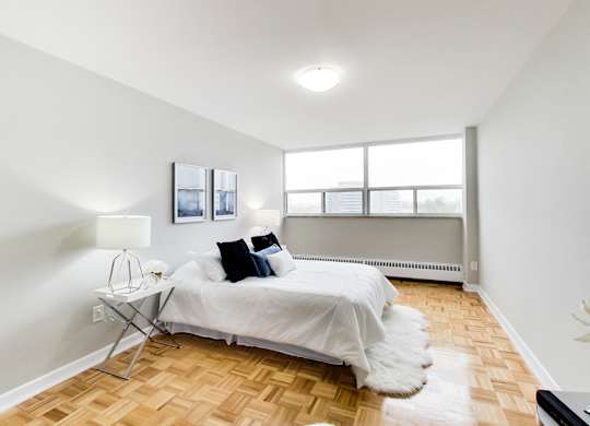 an apartment bedroom with a bed and a window