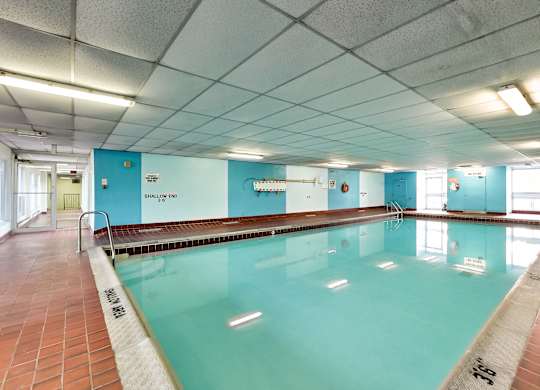 a large swimming pool in a building with blue walls