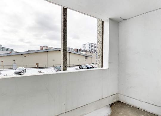 an empty room with a large window overlooking a parking lot
