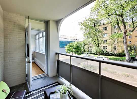 A balcony with a table and chairs overlooking a street.