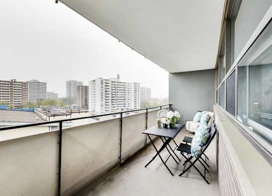 a balcony with a table and chairs and a view of the city