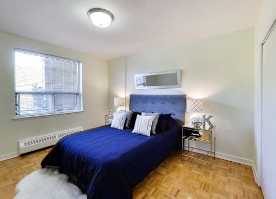 a bedroom with a blue bed and a window
