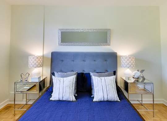 a bedroom with a blue bed and a blue blanket and pillows