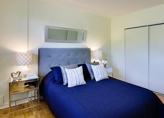 a bedroom with a blue bed and white walls