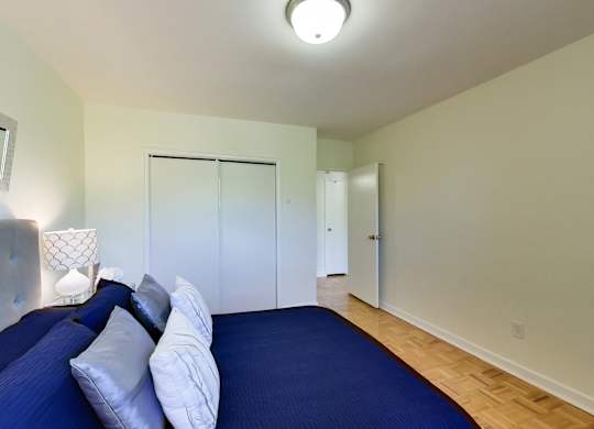 a bedroom with a large blue bed and a closet