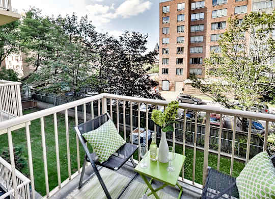 a balcony with two chairs and a table on it