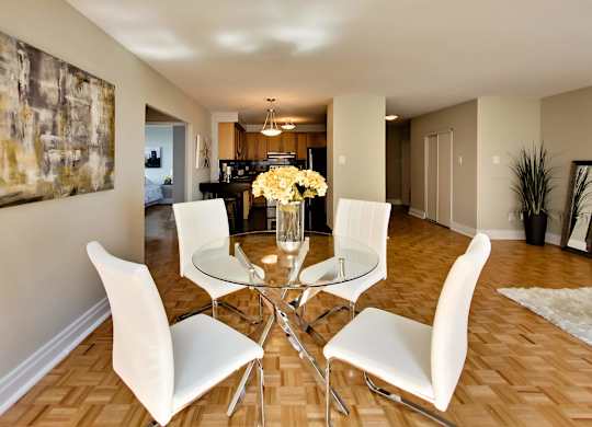 a dining room with a glass table and white chairs