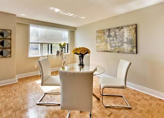 a dining room with a table and chairs and a window