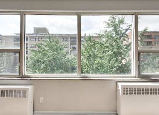 a room with a large window and a view of trees