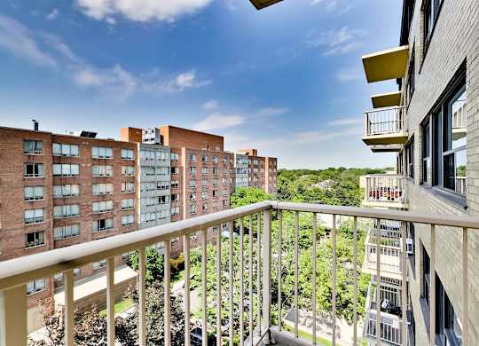 a balcony with a view of some buildings and trees