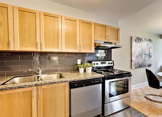 a modern kitchen with stainless steel appliances and wooden cabinets
