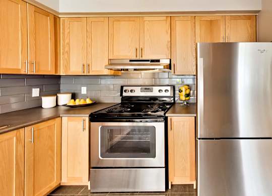 a kitchen with stainless steel appliances and wooden cabinets