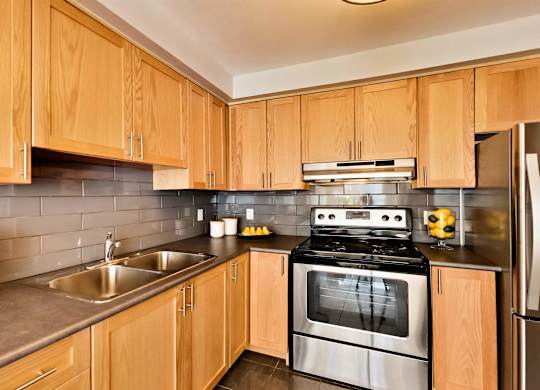 a modern kitchen with wooden cabinets and stainless steel appliances