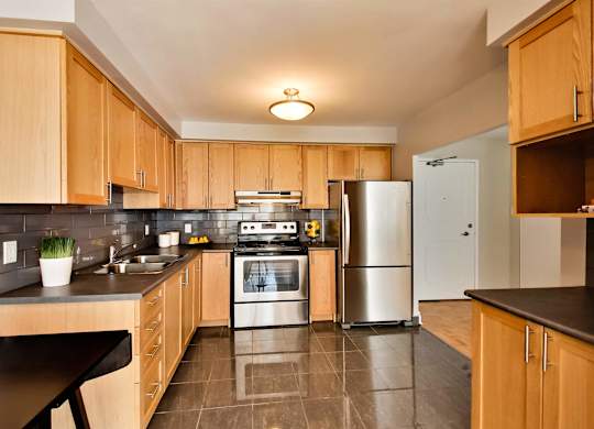 a kitchen with wooden cabinets and stainless steel appliances