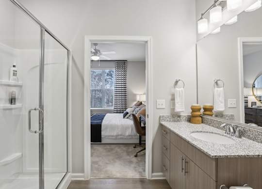 a bathroom with granite countertops and a walk-in shower