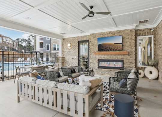 an outdoor patio area with a television and ceiling fan