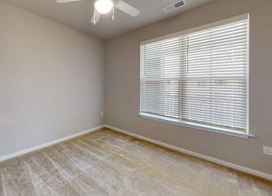 a bedroom with a ceiling fan and large window