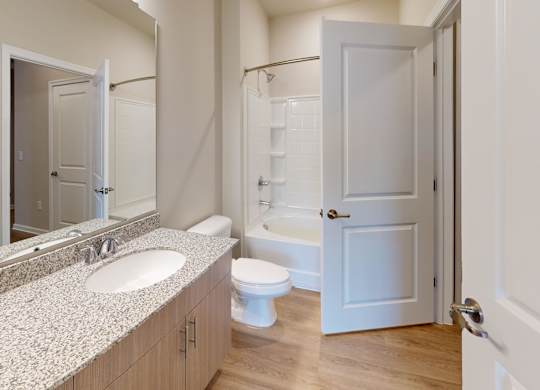 a bathroom with granite countertops and a tub